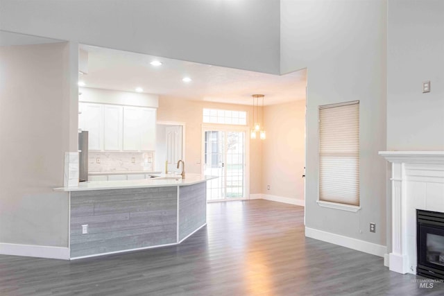 kitchen with pendant lighting, backsplash, white cabinetry, and dark wood-type flooring