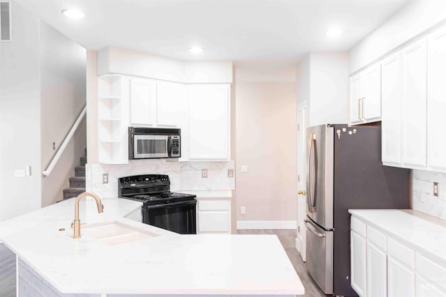 kitchen featuring white cabinetry, sink, tasteful backsplash, light stone counters, and appliances with stainless steel finishes