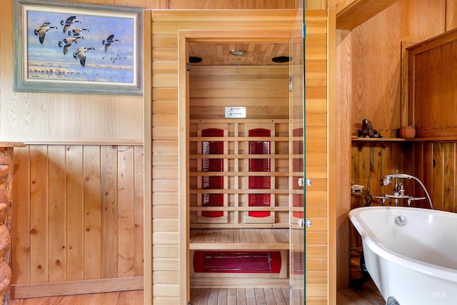 interior space featuring a bath and wood walls