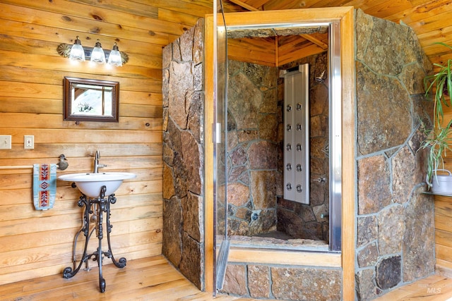 bathroom with a shower, wood-type flooring, wood walls, and wood ceiling