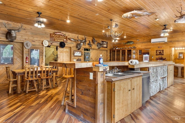 kitchen featuring a wall unit AC, wood-type flooring, wood walls, sink, and wood ceiling