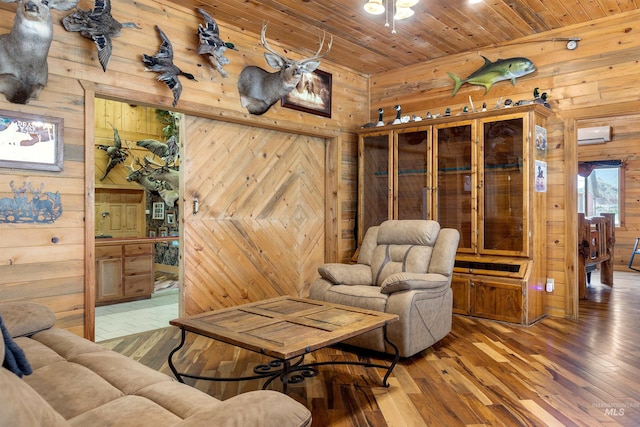 living room with a wall mounted AC, wood walls, hardwood / wood-style flooring, and wooden ceiling