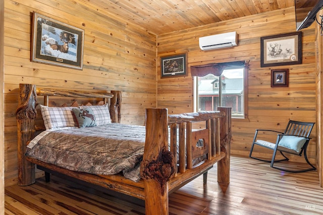 bedroom with hardwood / wood-style flooring, wood ceiling, wood walls, and an AC wall unit