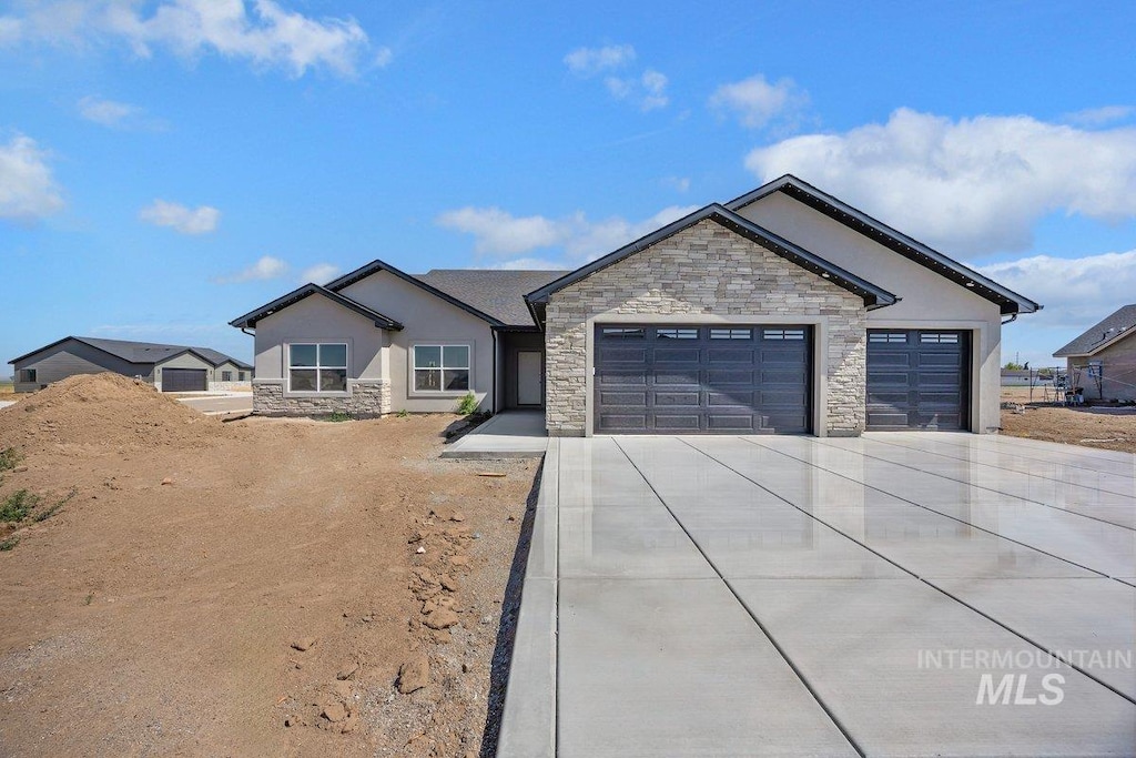 1552 W Ruby, Rupert, ID 83350 - ranch-style house with stone siding, concrete driveway, stucco siding, and an attached garage