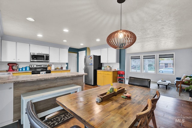 dining area with dark hardwood / wood-style flooring, a textured ceiling, and sink