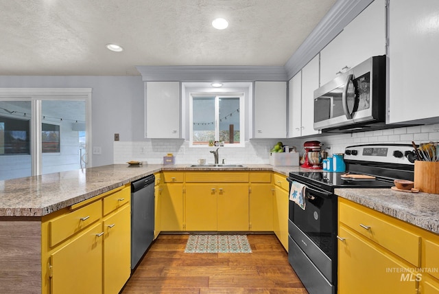 kitchen with hardwood / wood-style floors, white cabinetry, sink, and appliances with stainless steel finishes