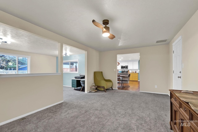 sitting room featuring light colored carpet and a textured ceiling