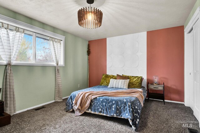 bedroom with carpet flooring, a closet, and a textured ceiling