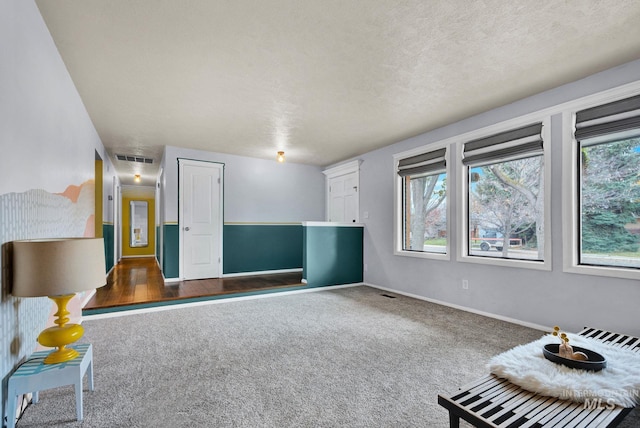 unfurnished room with dark carpet and a textured ceiling