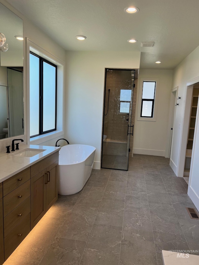 3075 N Costa Madera Ave, Star, ID 83669 - bathroom featuring a shower stall, vanity, a soaking tub, baseboards, and recessed lighting