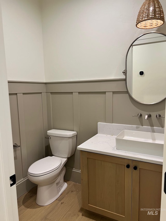 3075 N Costa Madera Ave, Star, ID 83669 - bathroom with a decorative wall, wood finished floors, vanity, toilet, and a wainscoted wall