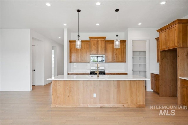 5351 W Mcnair St, Meridian, ID 83646 - kitchen featuring stainless steel appliances, light wood-style flooring, brown cabinetry, and recessed lighting