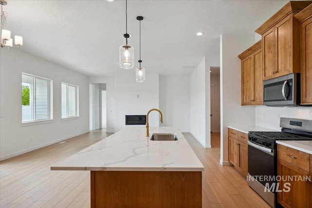 5351 W Mcnair St, Meridian, ID 83646 - kitchen with appliances with stainless steel finishes, a sink, brown cabinets, light wood-style flooring, and recessed lighting
