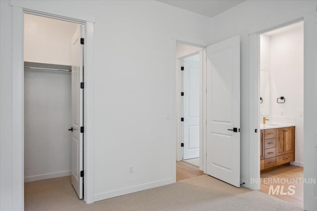 5351 W Mcnair St, Meridian, ID 83646 - unfurnished bedroom featuring a closet, connected bathroom, baseboards, and light colored carpet