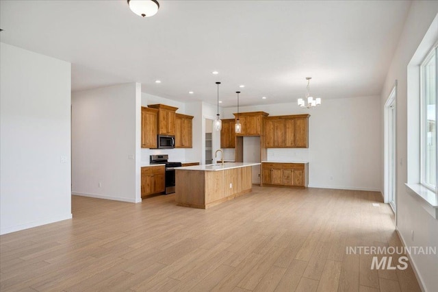 5351 W Mcnair St, Meridian, ID 83646 - kitchen featuring stainless steel appliances, brown cabinets, a chandelier, a sink, and light wood-style flooring