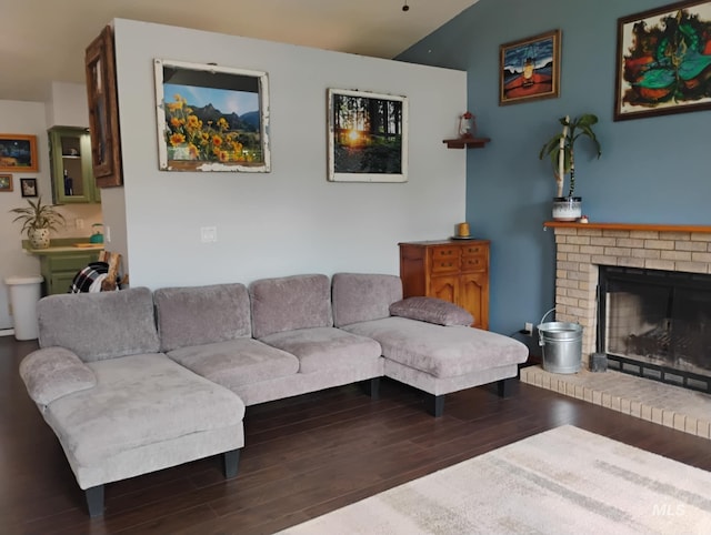 living area featuring wood finished floors and a brick fireplace