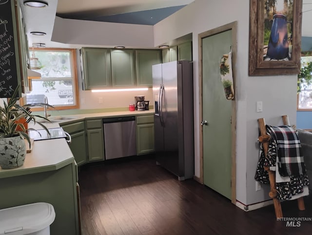 kitchen featuring green cabinetry, stainless steel appliances, light countertops, dark wood-style flooring, and a sink