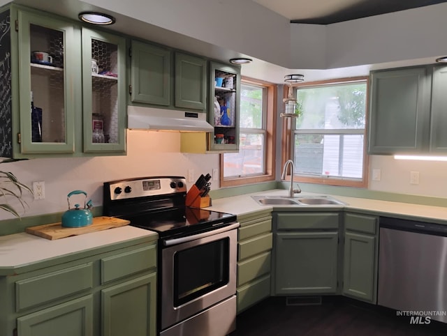 kitchen featuring stainless steel appliances, under cabinet range hood, and green cabinetry