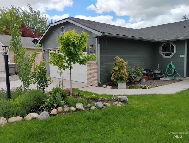 view of home's exterior with a garage, a yard, concrete driveway, and a shingled roof