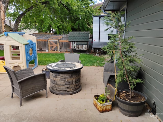 view of patio featuring an outdoor fire pit and fence
