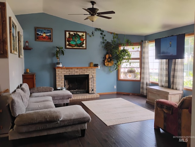 living area with lofted ceiling, a ceiling fan, a brick fireplace, and wood finished floors