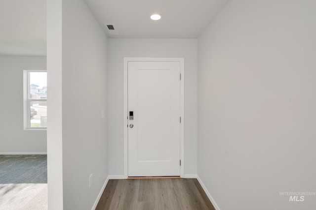 hallway with visible vents, recessed lighting, wood finished floors, and baseboards