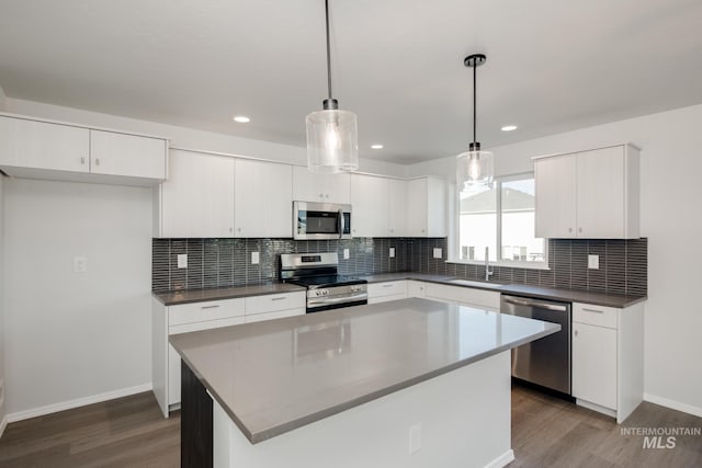 kitchen featuring dark wood-style floors, white cabinets, appliances with stainless steel finishes, and a sink