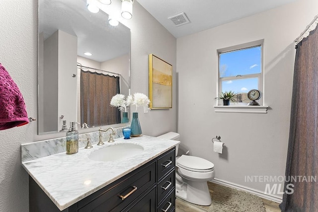 2817 W Chartwell Dr, Eagle, ID 83616 - bathroom featuring vanity, wood finished floors, toilet, and baseboards