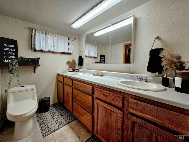 bathroom featuring a sink, double vanity, toilet, and tile patterned floors