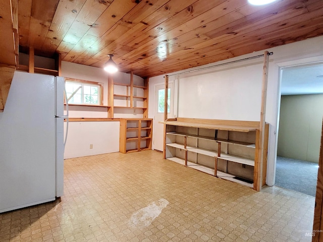 basement with freestanding refrigerator, tile patterned floors, and wooden ceiling