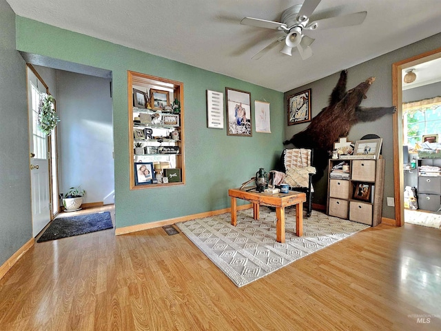 office area featuring a ceiling fan, baseboards, and wood finished floors