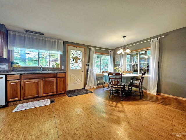 dining room featuring a notable chandelier, baseboards, and wood finished floors