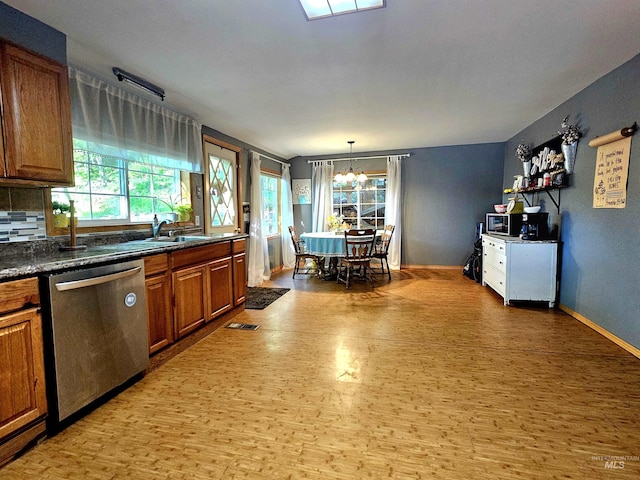 kitchen with dark countertops, stainless steel appliances, brown cabinetry, light wood-type flooring, and visible vents