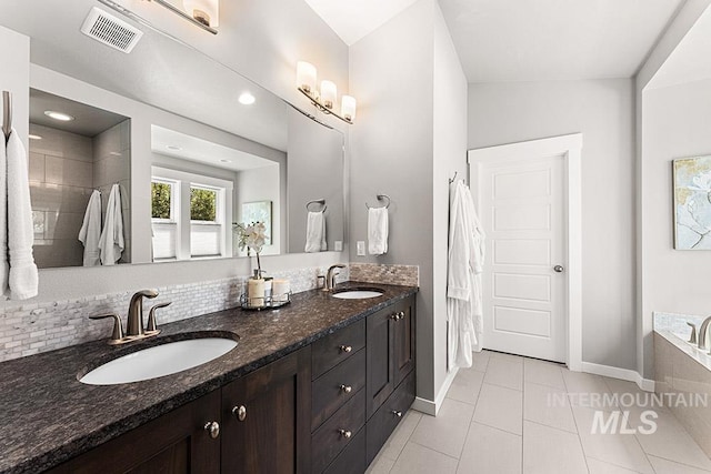 full bath featuring a tub, visible vents, a sink, and tile patterned flooring