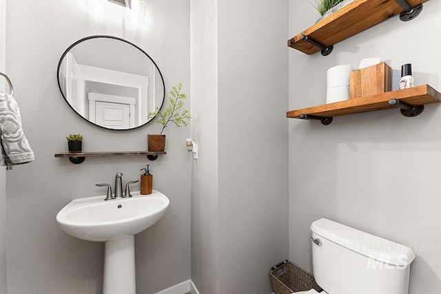 bathroom featuring baseboards and toilet