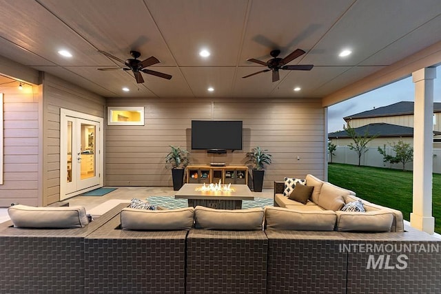 living area with wood walls, a ceiling fan, and recessed lighting