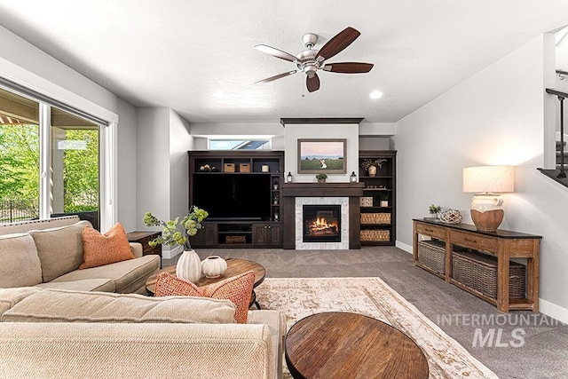 living area featuring a ceiling fan, a wealth of natural light, and carpet