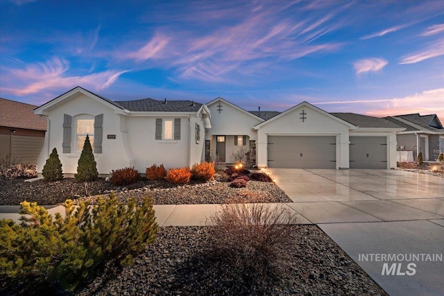 single story home featuring a garage, concrete driveway, and stucco siding