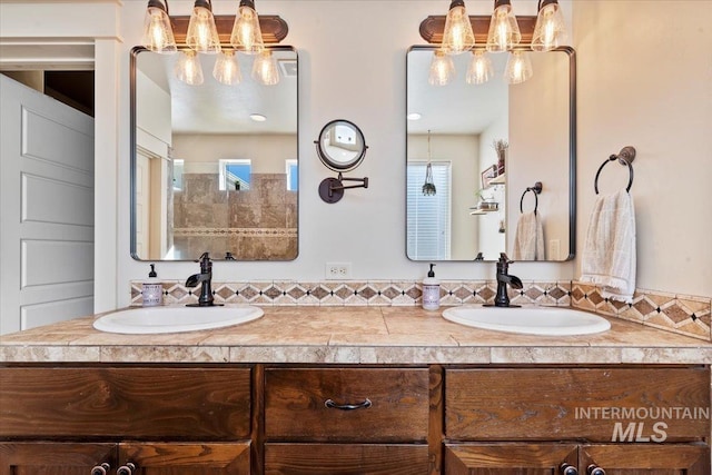 bathroom featuring double vanity, an inviting chandelier, and a sink