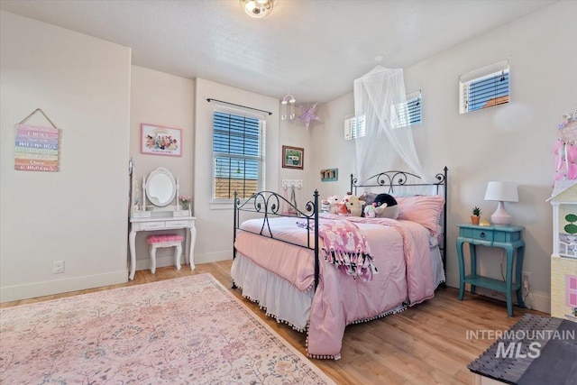 bedroom featuring baseboards and wood finished floors