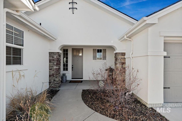 view of exterior entry with stucco siding and stone siding