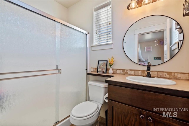 full bath featuring toilet, a stall shower, and vanity