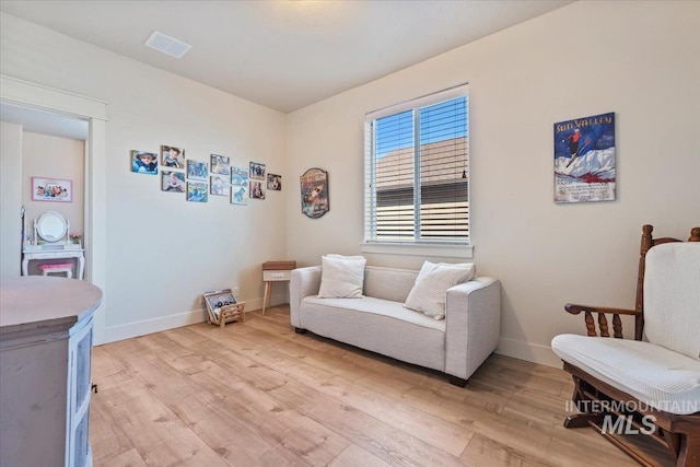 sitting room with visible vents, baseboards, and light wood-style floors