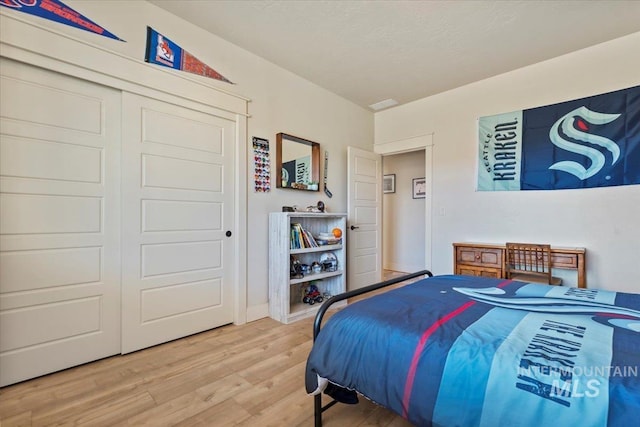 bedroom with wood finished floors and a closet