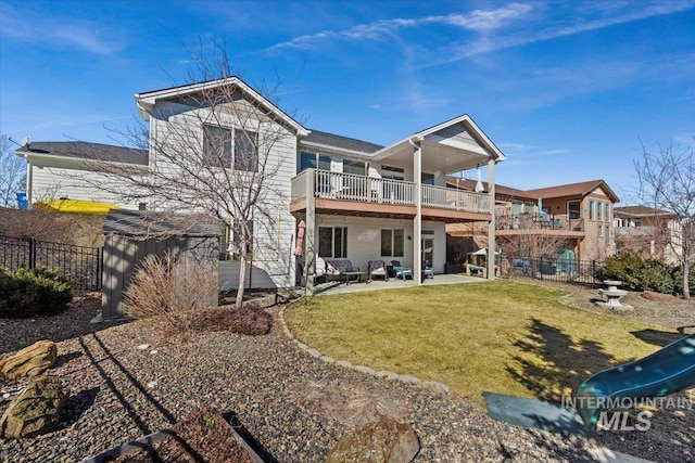 back of house featuring outdoor lounge area, a patio area, fence, and a lawn