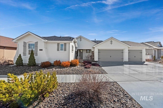 ranch-style home with stucco siding, an attached garage, and driveway