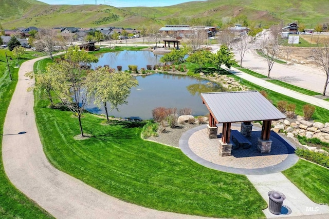 view of property's community with a lawn and a water and mountain view