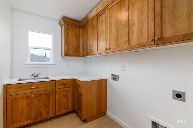 12510 W Wild Thistle Dr, Star, ID 83669 - laundry room with hookup for an electric dryer, hookup for a washing machine, cabinet space, light wood-style floors, and baseboards