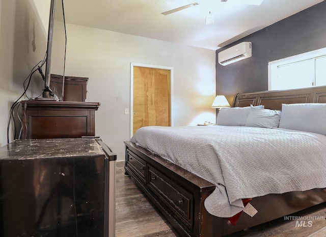 bedroom featuring dark wood-style floors and an AC wall unit