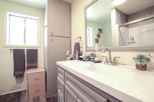 bathroom featuring a stall shower, vanity, and wood finished floors